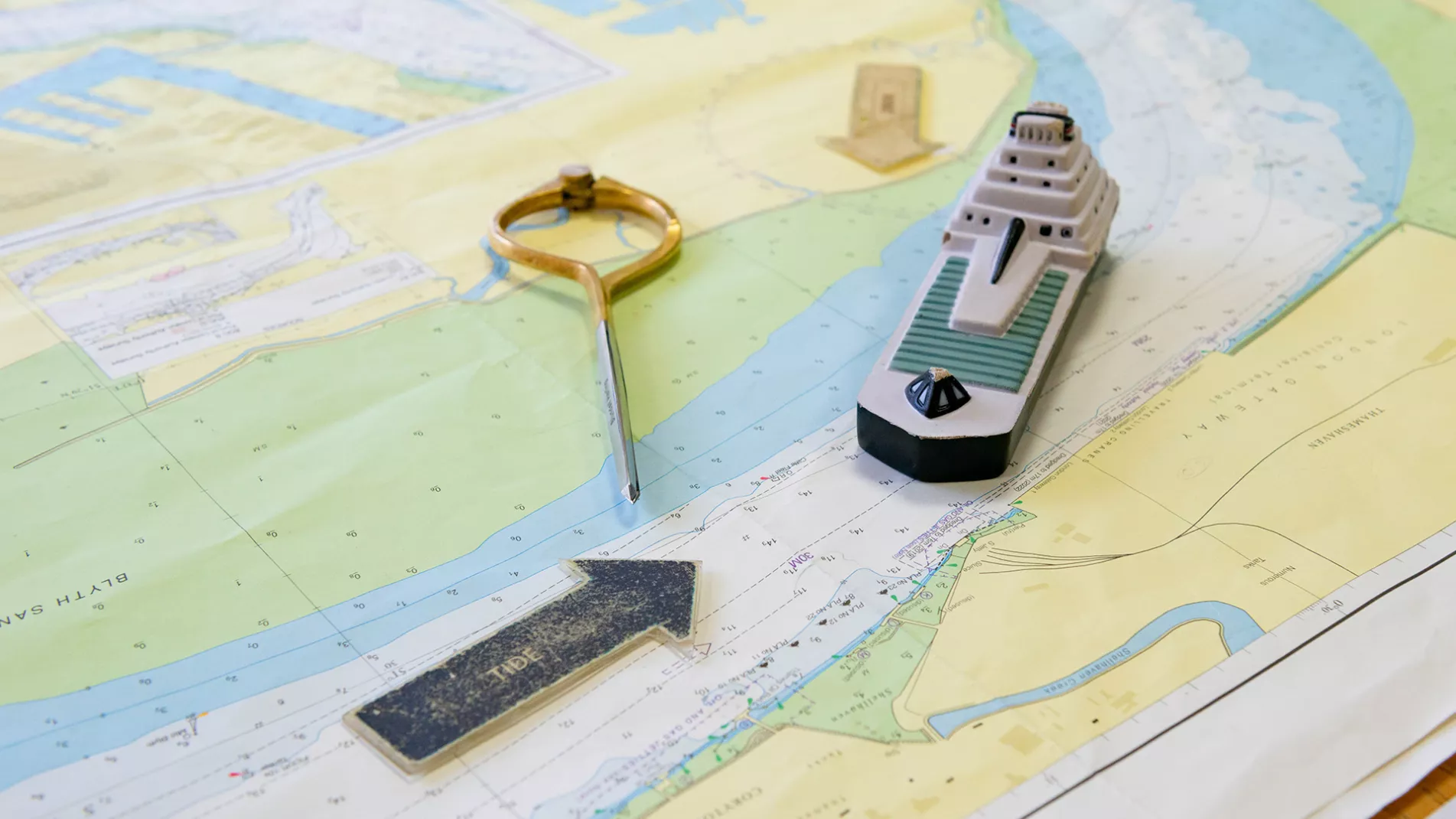 Model of boat and arrows on a map laid on a table