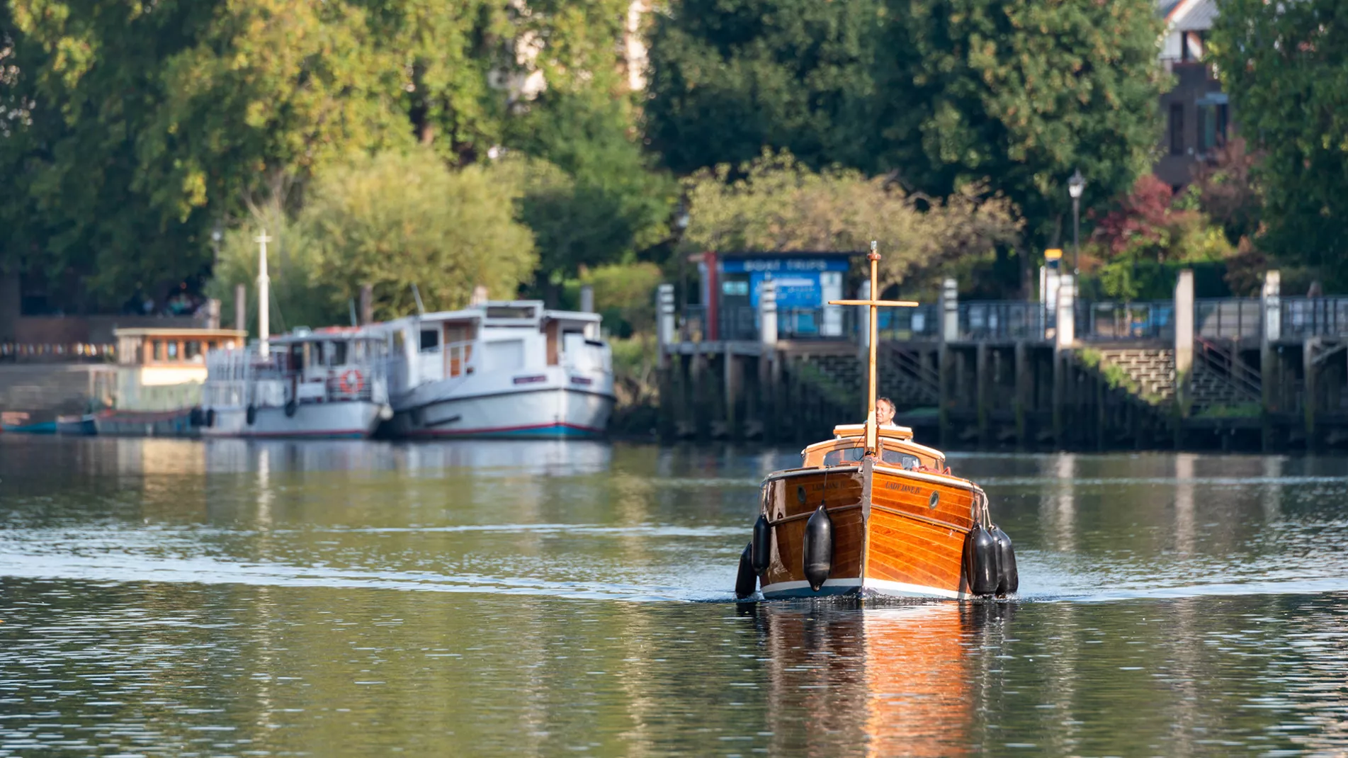 Classic wooden boat cruising on the tidal Thames