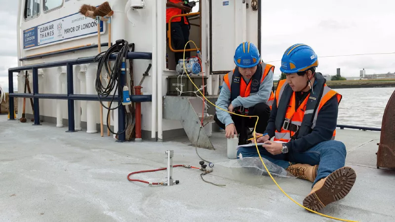 Two PLA employees sat on the deck of Driftwood II testing air quality