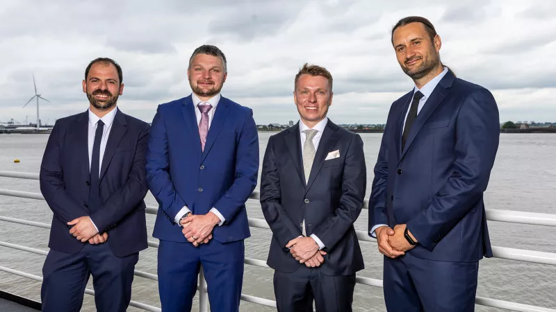Four new PLA trainee pilots stand with the River Thames in the background
