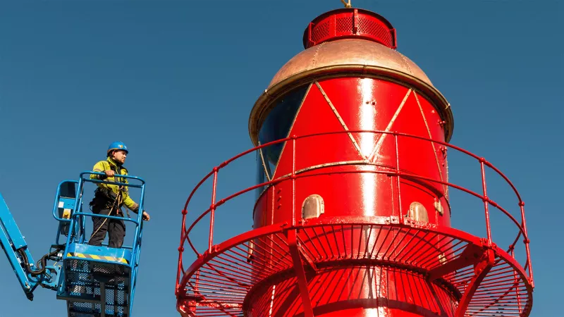 Restored Shornemead Lighthouse and man on cherry picker