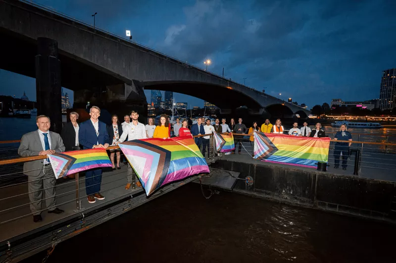 River employees with Waterloo Bridge in background and pride flags