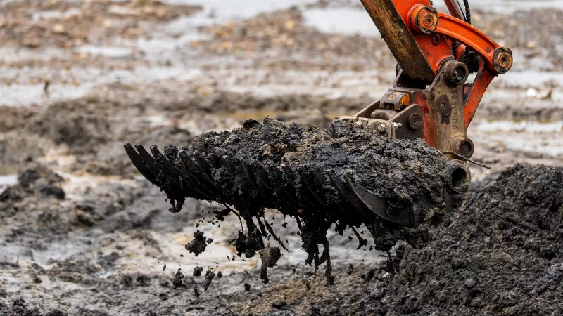 Excavator picking wet wipes off of Wet Wipe Island
